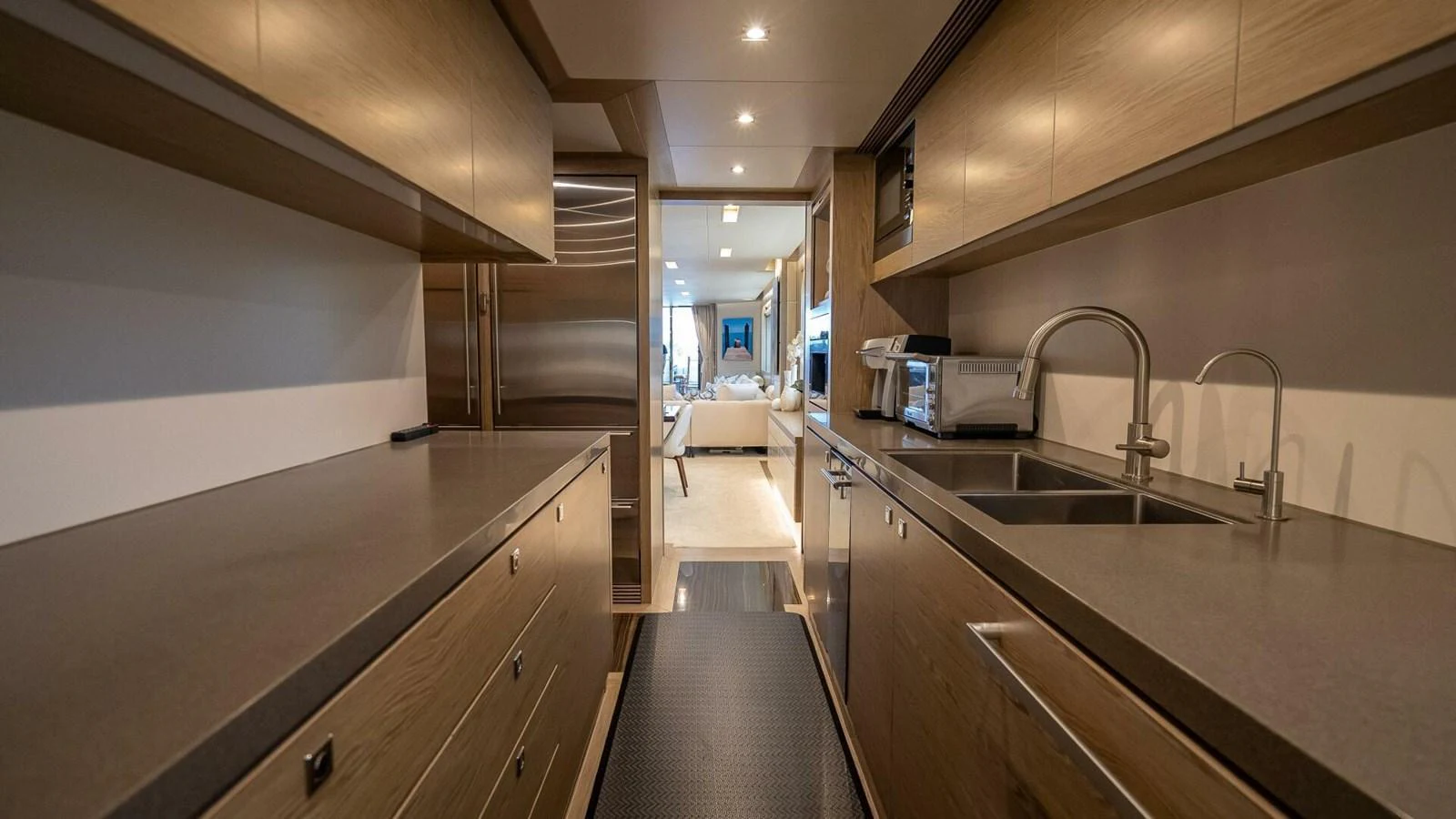 The modern galley features sleek countertops and ample storage, leading to a cozy seating area. aboard SHORT STORY Yacht for Sale