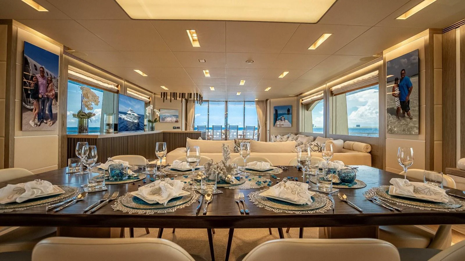 The yacht's dining area features an elegant table setting with panoramic views through large windows. aboard SHORT STORY Yacht for Sale