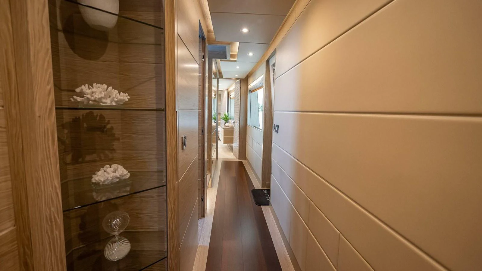 A well-lit hallway with elegant wooden paneling and decorative shelves. aboard SHORT STORY Yacht for Sale