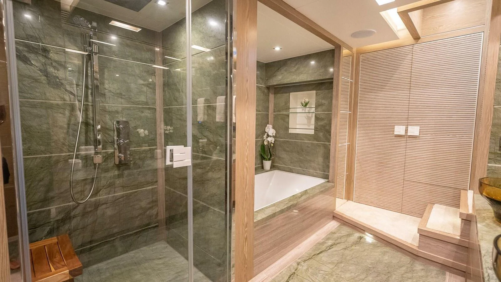 The yacht's bathroom features luxurious green marble and modern fixtures. aboard SHORT STORY Yacht for Sale