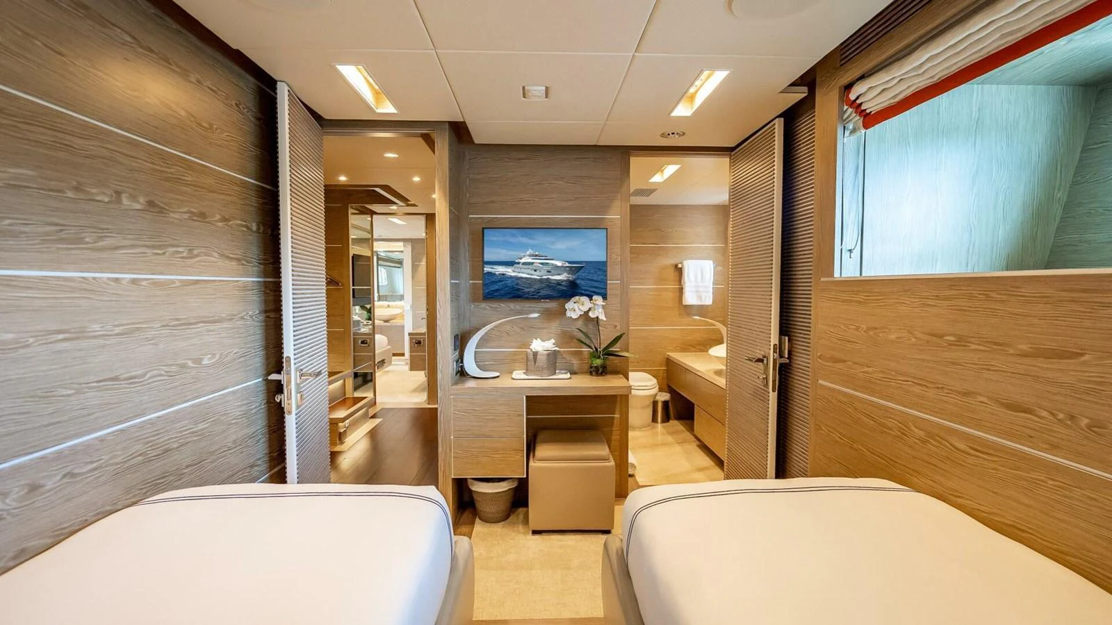 The guest stateroom features twin beds and a modern, elegant design with wood paneling and ample natural light. aboard SHORT STORY Yacht for Sale