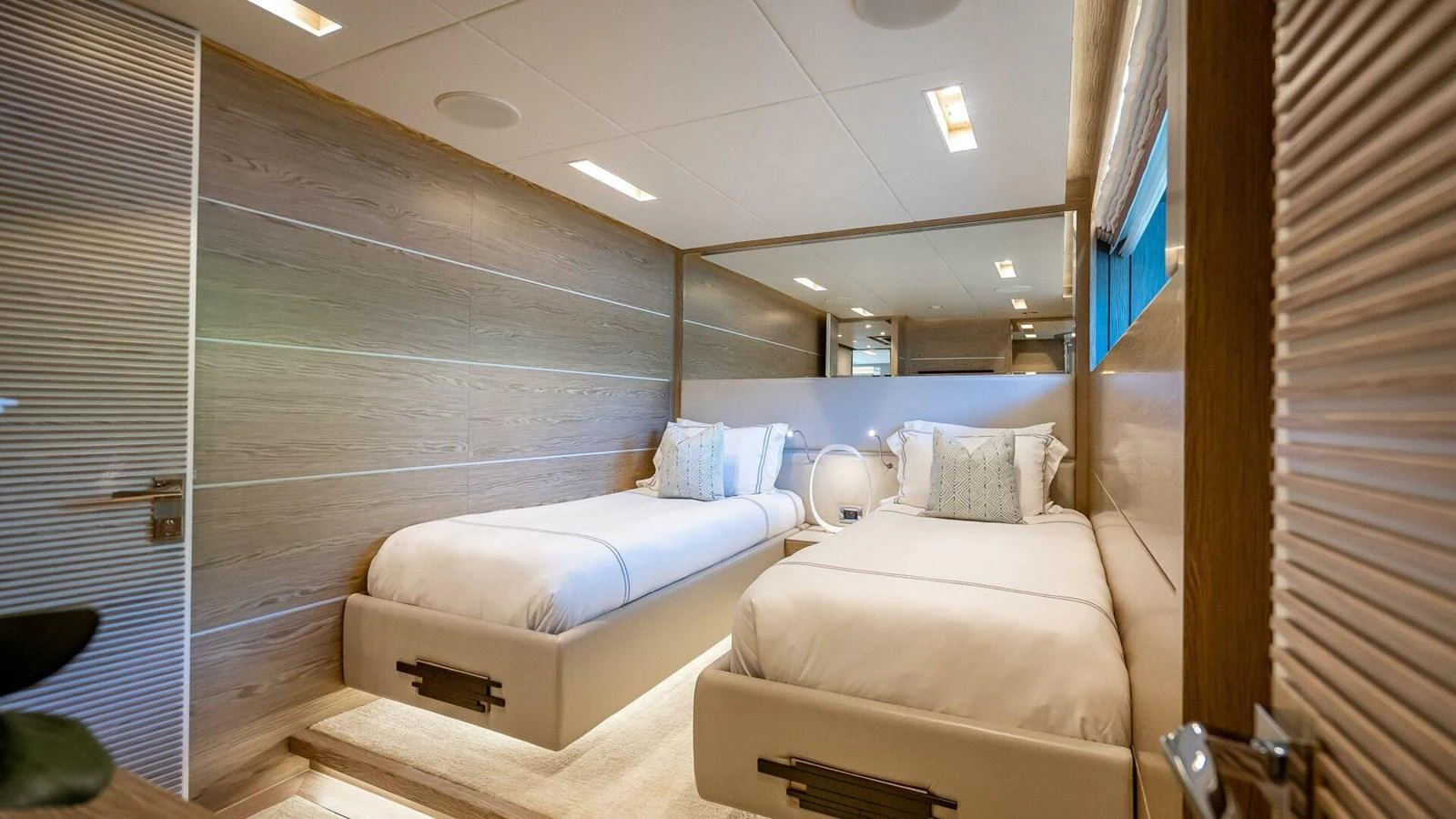 The guest stateroom features twin beds and a modern, elegant design with warm wood tones and soft lighting. aboard SHORT STORY Yacht for Sale