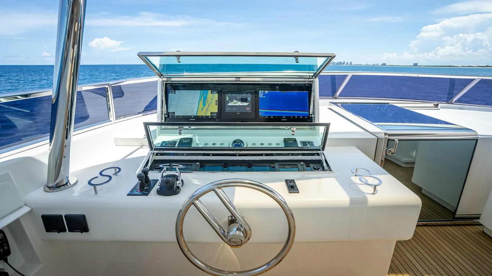 The helm station features advanced navigation equipment and a sleek steering wheel, set against a backdrop of open sea. aboard SHORT STORY Yacht for Sale