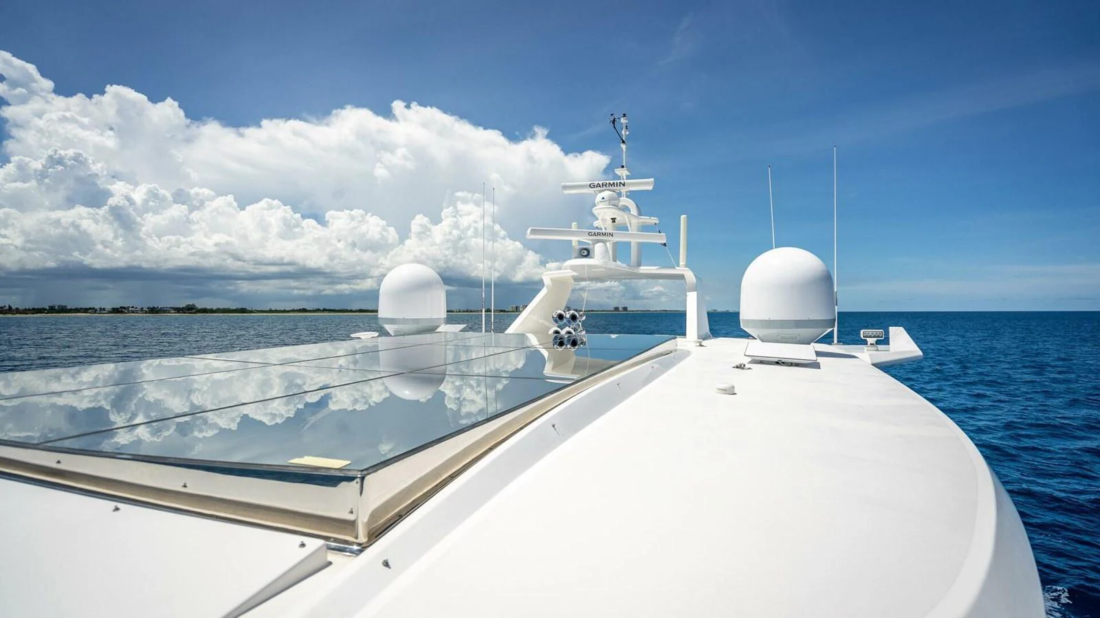 The yacht's sleek exterior features advanced navigation equipment and a spacious deck under a clear blue sky. aboard SHORT STORY Yacht for Sale