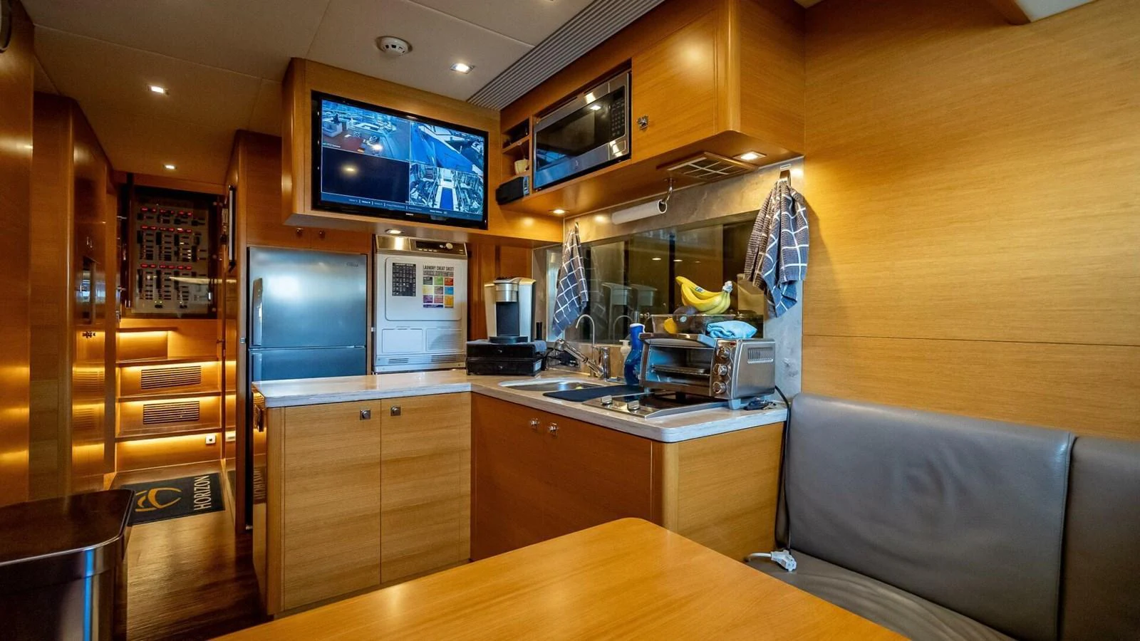The yacht's galley is equipped with modern appliances and warm wooden cabinetry, creating a cozy and functional space. aboard SHORT STORY Yacht for Sale