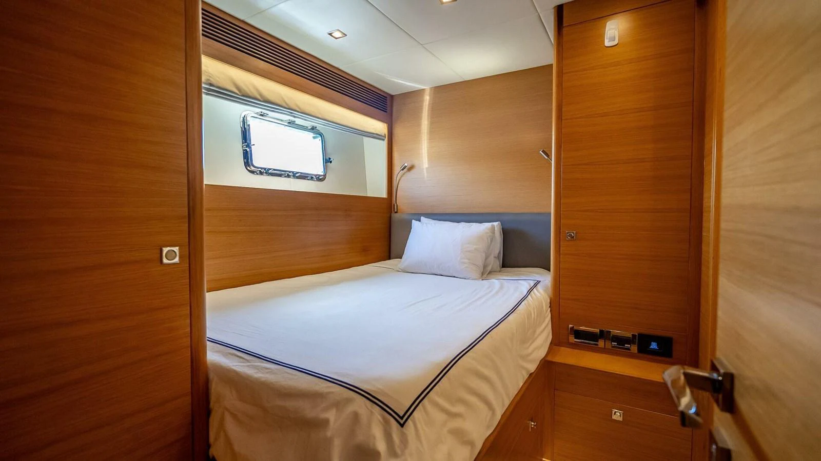 A cozy guest stateroom with a comfortable bed and warm wooden finishes. aboard SHORT STORY Yacht for Sale