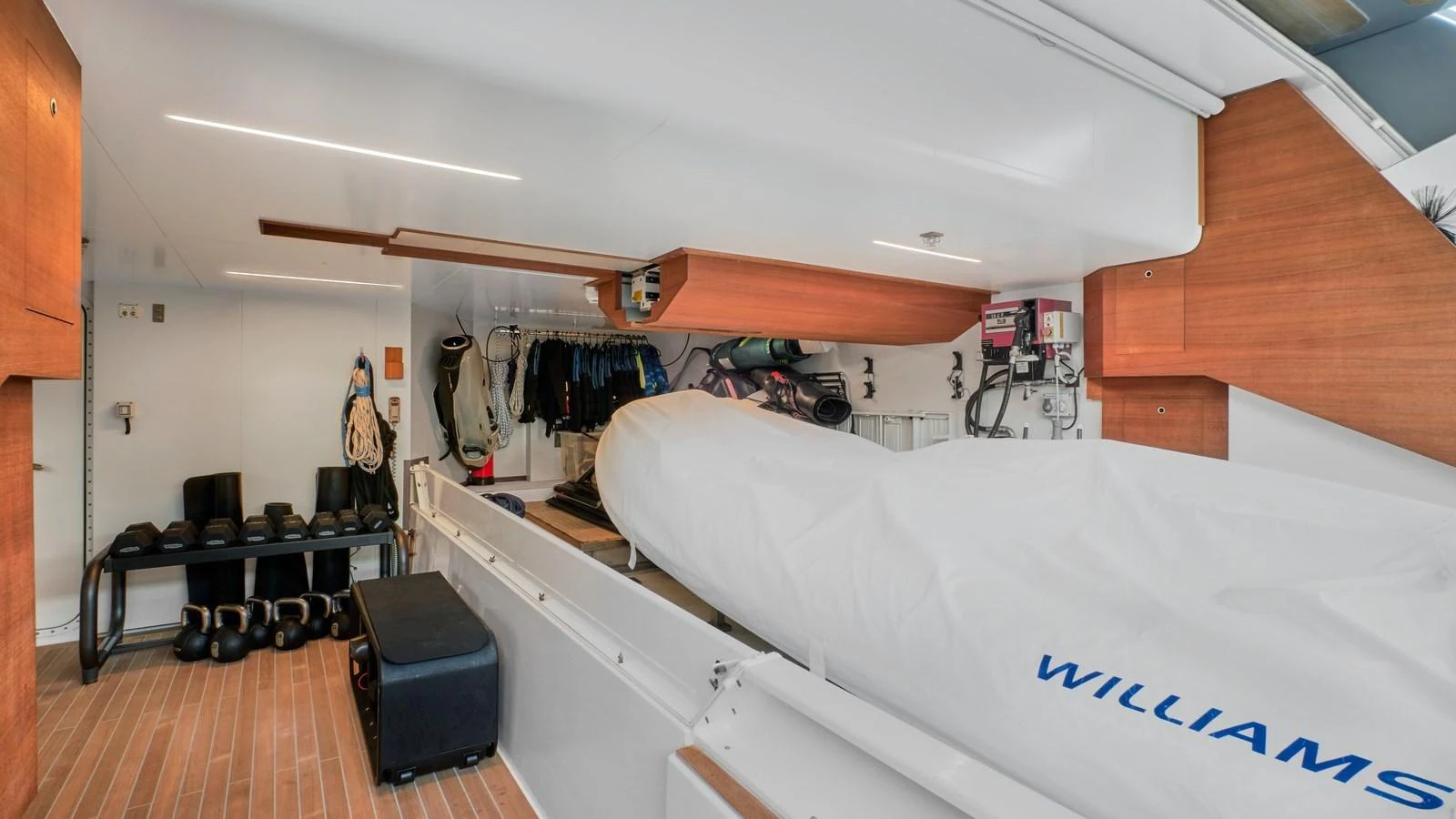 The yacht's tender garage is well-organized, featuring a covered Williams tender and various equipment. aboard BIZMAN Yacht for Sale