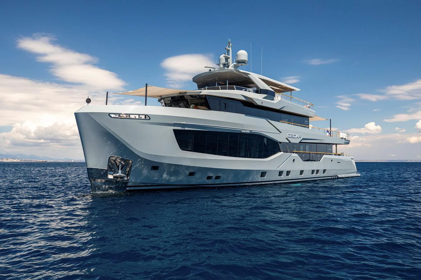 A sleek and modern yacht glides gracefully on the open sea under a clear blue sky. aboard OSCAR Yacht for Sale