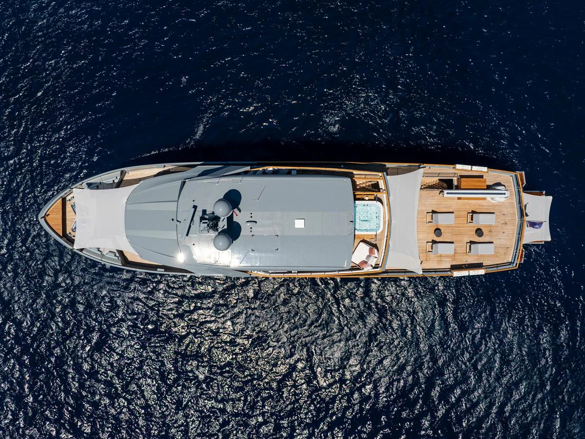 Aerial view of a sleek yacht cruising on deep blue waters, showcasing its spacious deck and luxurious amenities. aboard OSCAR Yacht for Sale