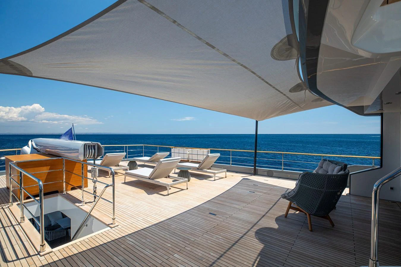 The sundeck offers a spacious and inviting area for relaxation with sun loungers and a shaded seating area overlooking the ocean. aboard OSCAR Yacht for Sale