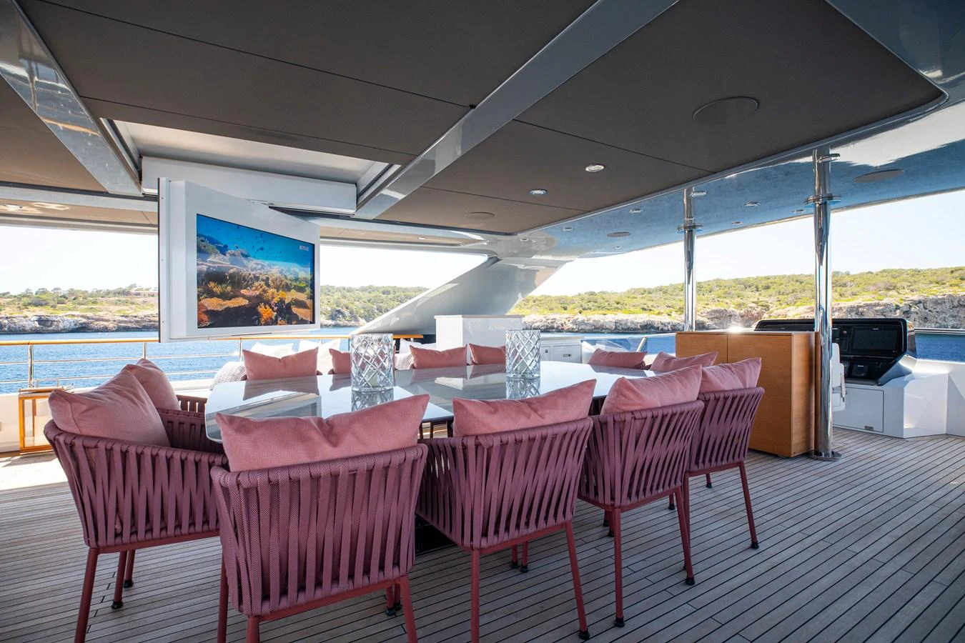 The aft deck features a spacious dining area with a large table and comfortable seating, perfect for al fresco meals with a view. aboard OSCAR Yacht for Sale