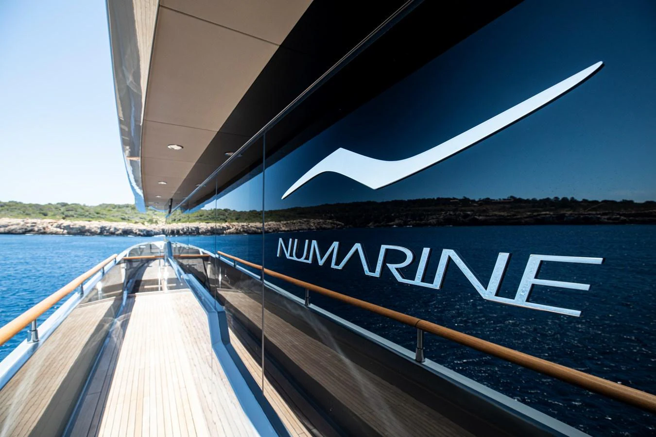 The sleek exterior of the yacht features a polished walkway with a stunning view of the surrounding water and landscape. aboard OSCAR Yacht for Sale