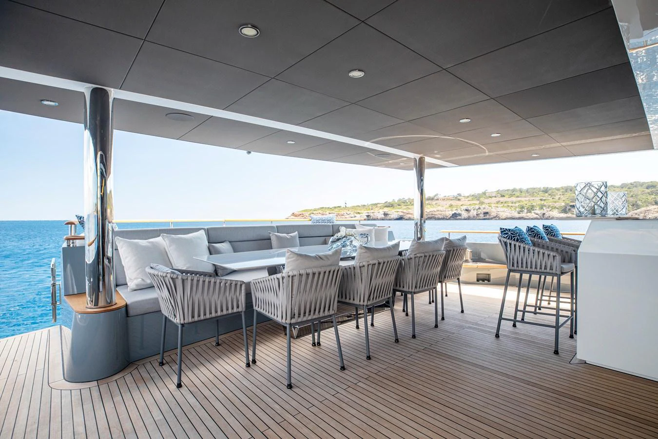 The aft deck features a spacious and elegant outdoor dining area with comfortable seating and stunning ocean views. aboard OSCAR Yacht for Sale