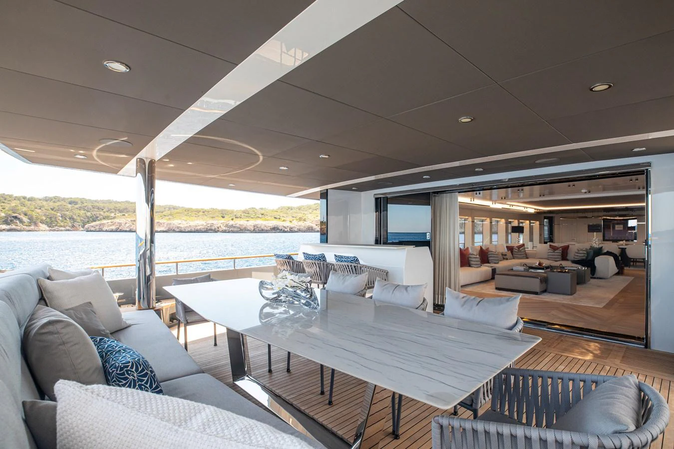 The aft deck features a spacious dining area with a stunning view of the water. aboard OSCAR Yacht for Sale