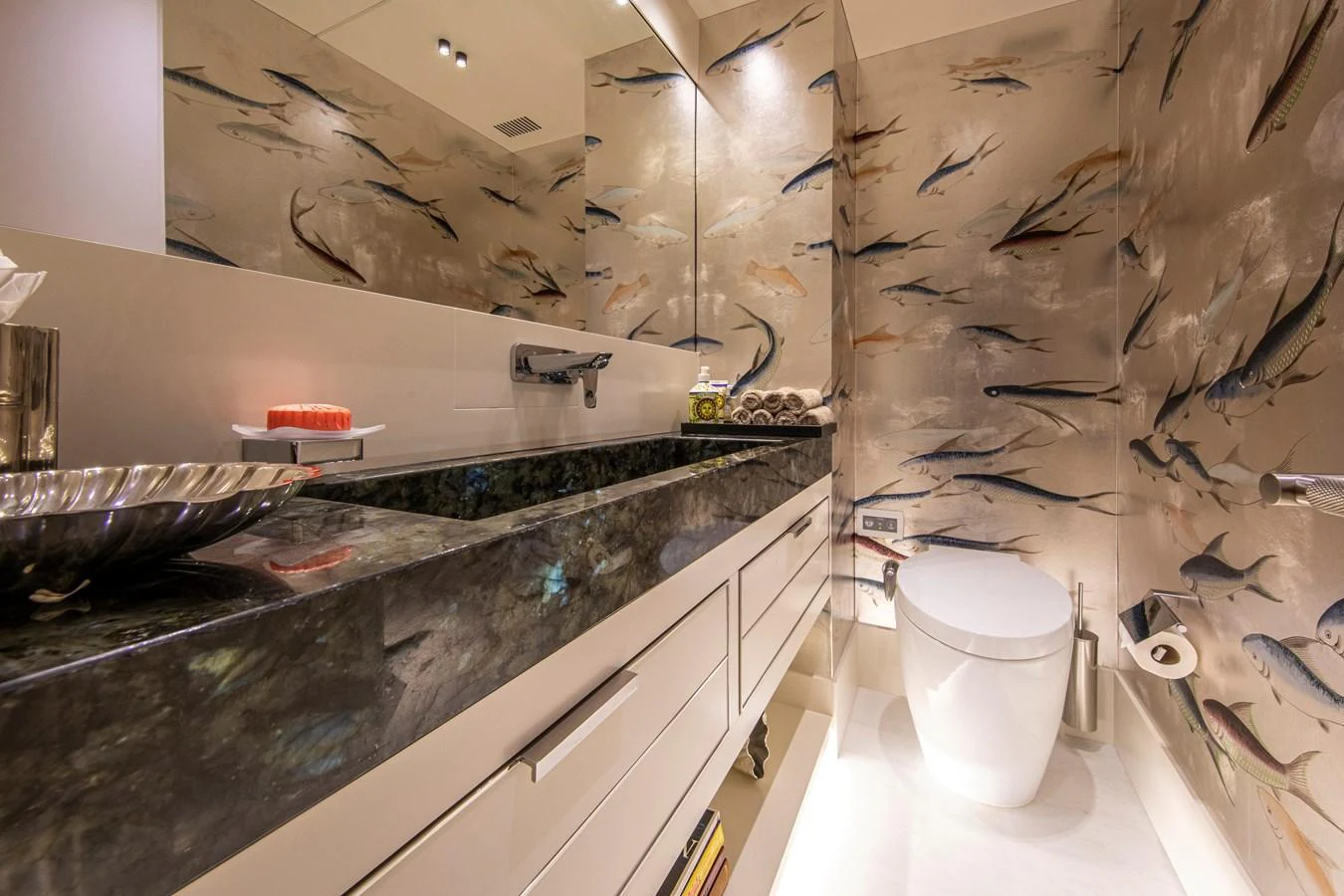 A luxurious yacht bathroom with a unique fish-themed wall design and modern fixtures. aboard OSCAR Yacht for Sale