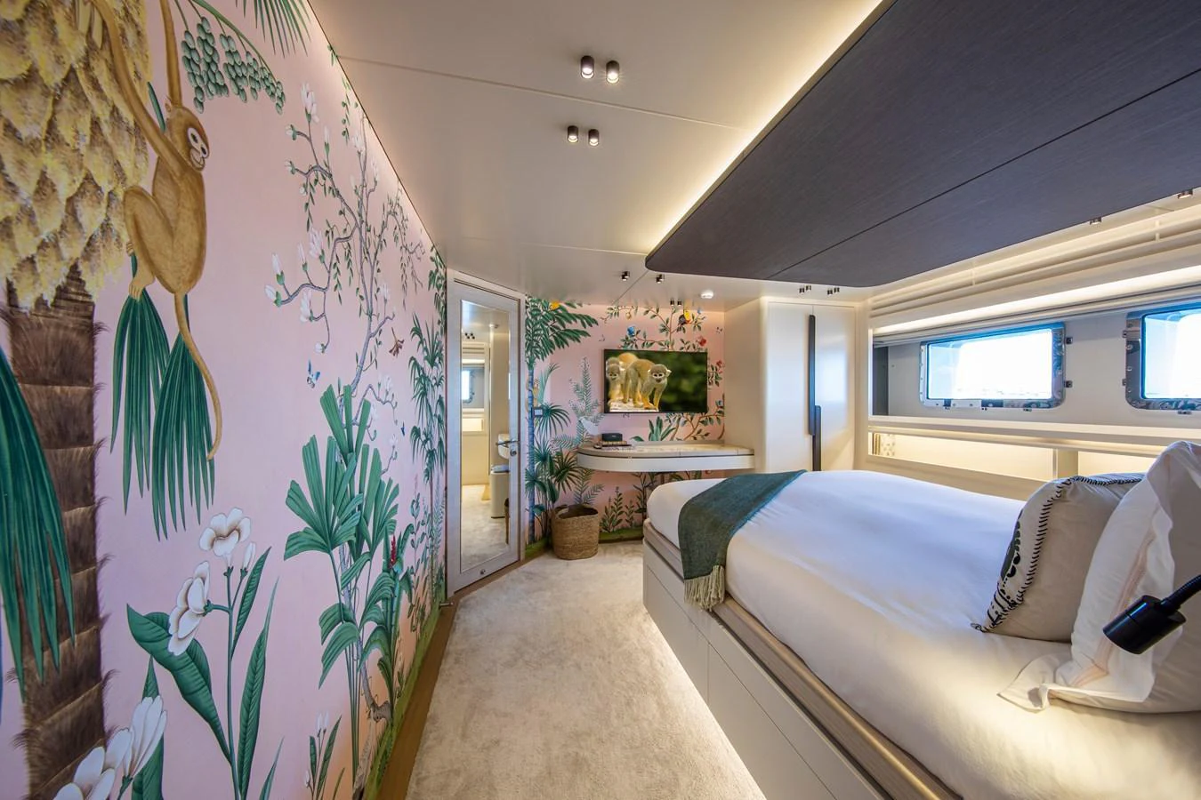 A luxurious stateroom featuring vibrant tropical-themed decor and modern amenities. aboard OSCAR Yacht for Sale