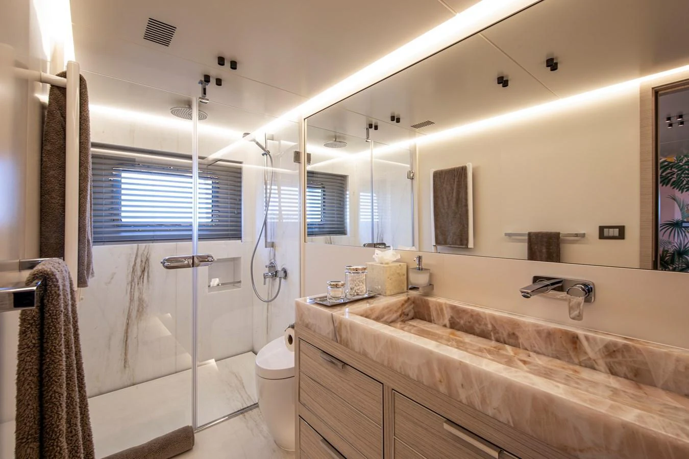 The yacht's bathroom features a luxurious marble sink and a spacious glass-enclosed shower. aboard OSCAR Yacht for Sale