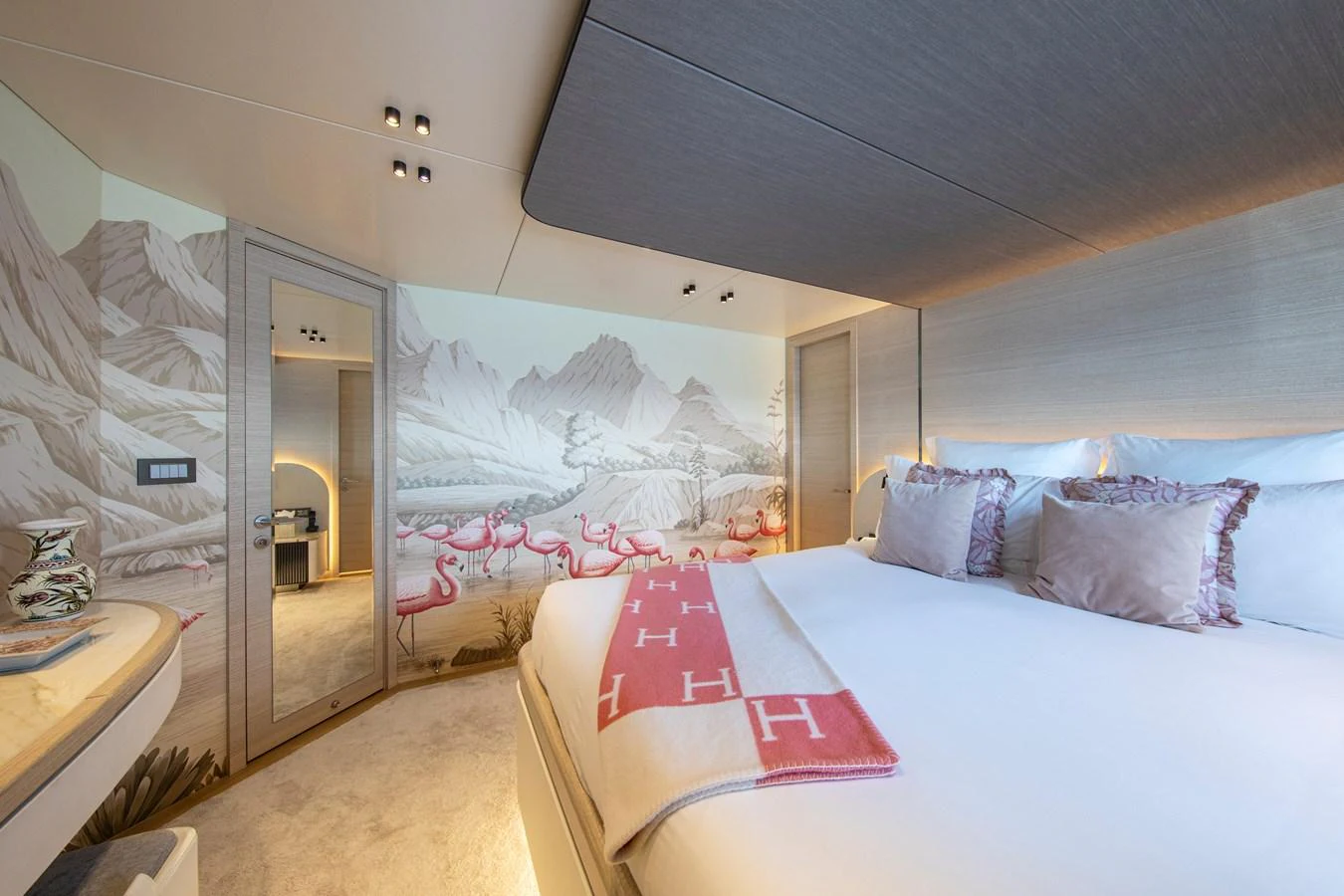 The stateroom features a luxurious bed with elegant decor and a scenic mural on the wall. aboard OSCAR Yacht for Sale