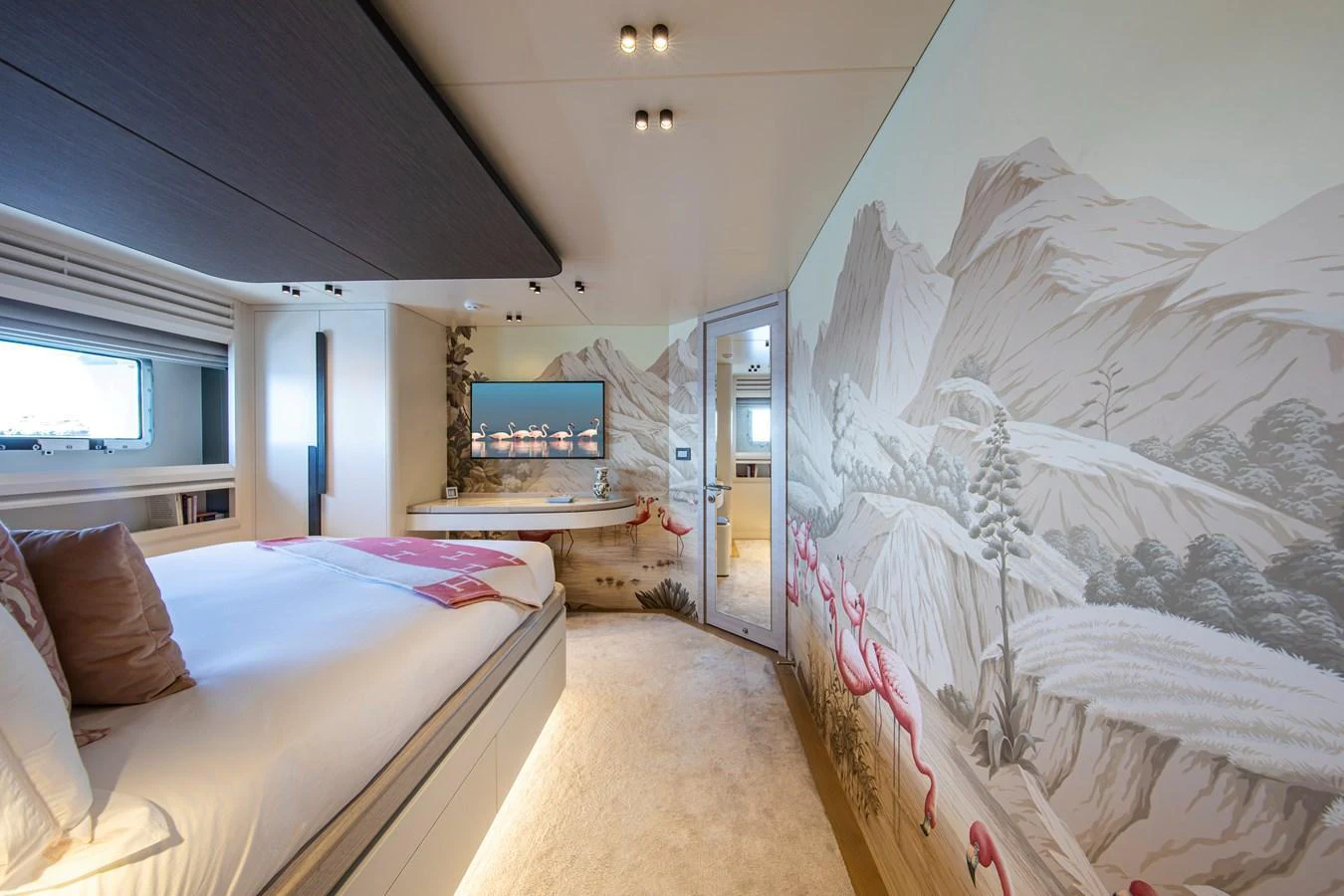 The stateroom features a luxurious bed, scenic wall art, and a flat-screen TV for ultimate comfort. aboard OSCAR Yacht for Sale