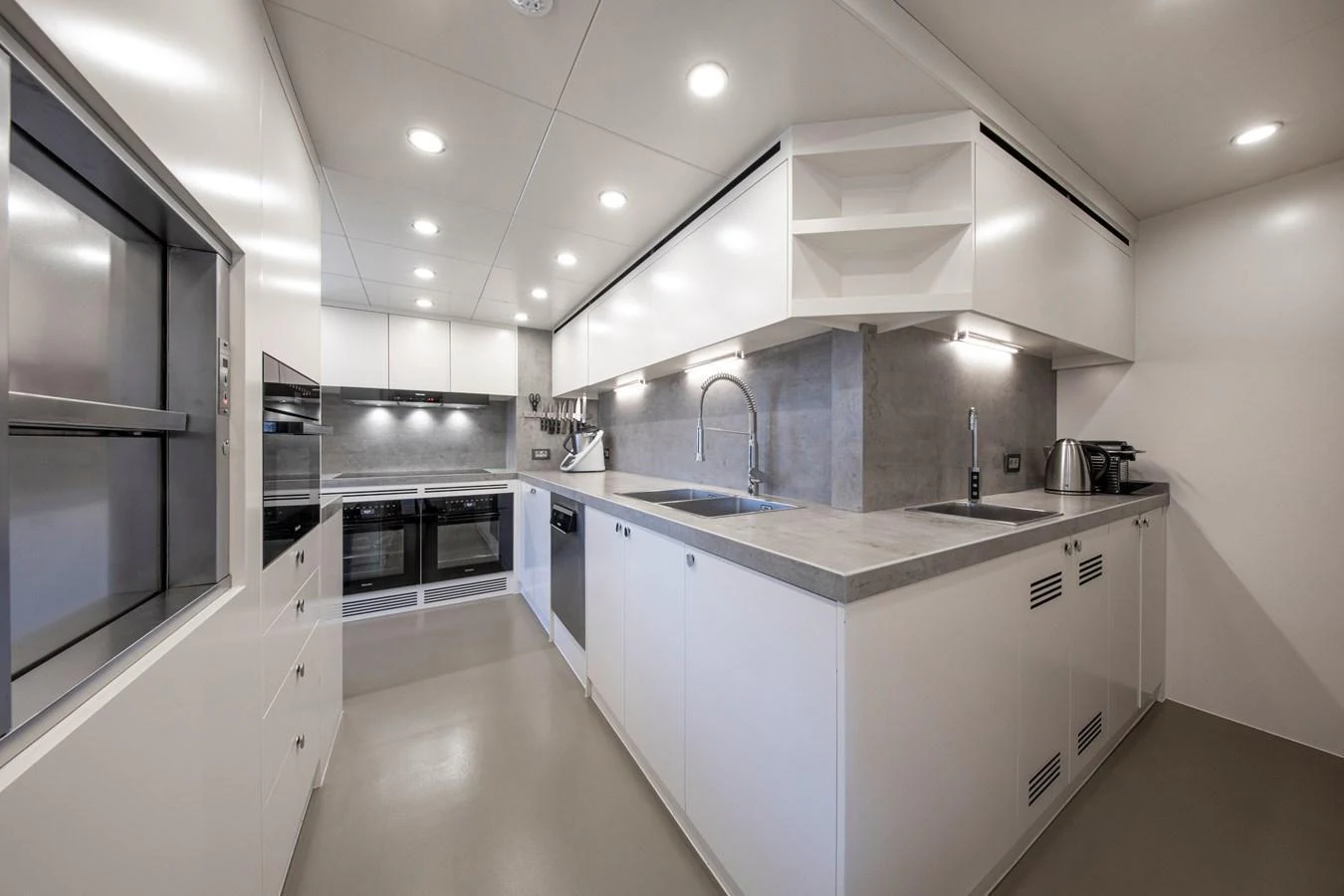 The yacht's galley is modern and well-equipped, featuring sleek cabinetry and ample counter space. aboard OSCAR Yacht for Sale