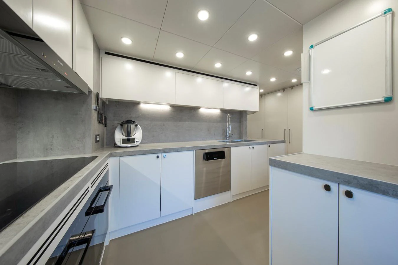 A modern and spacious galley with sleek white cabinetry and stainless steel appliances. aboard OSCAR Yacht for Sale