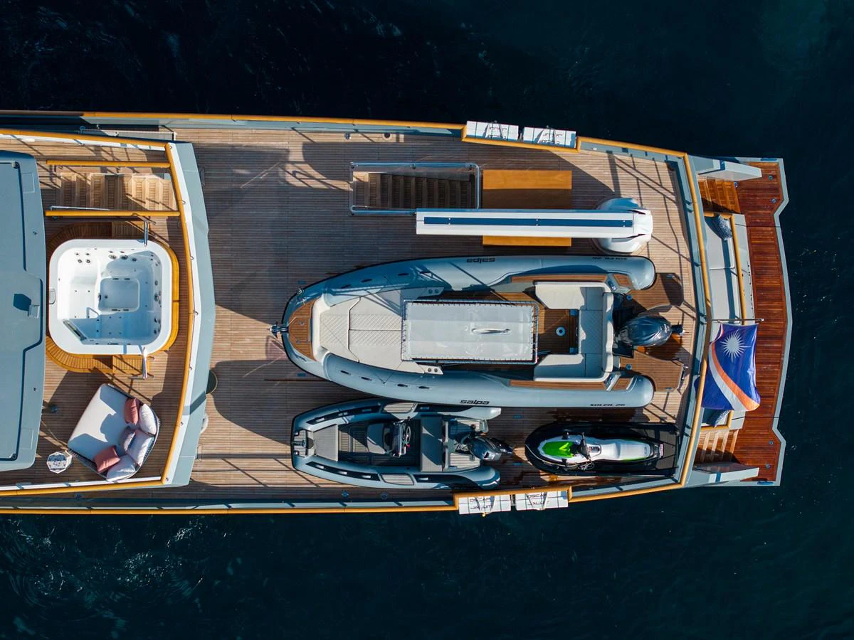 The aft deck features a spacious layout with a jacuzzi, sun loungers, and multiple water toys. aboard OSCAR Yacht for Sale