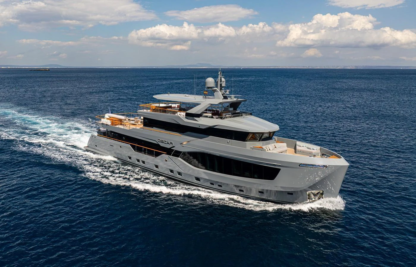 A sleek and modern yacht cruising on open waters under a clear sky. aboard OSCAR Yacht for Sale