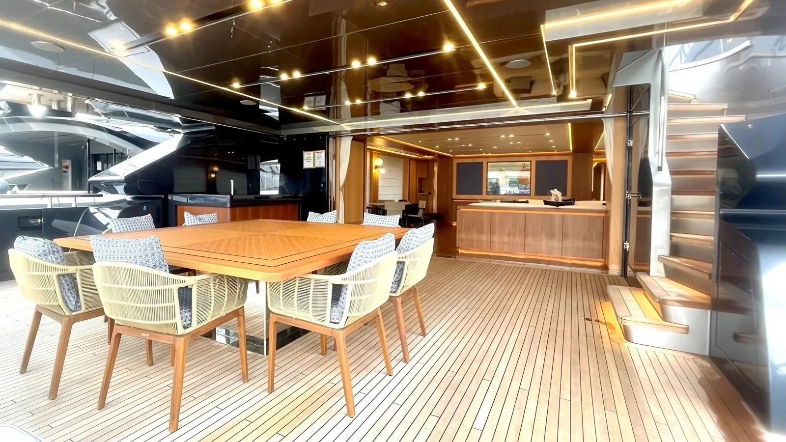 The aft deck features a spacious dining area with elegant wooden furniture and modern lighting. aboard LADY BETTY Yacht for Sale