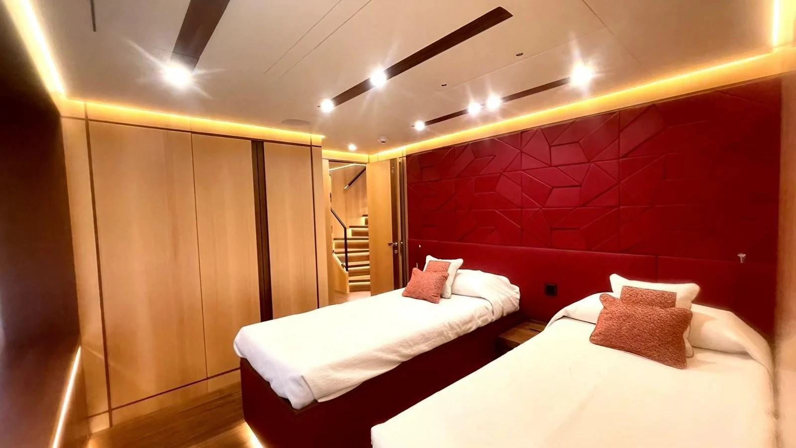 The guest stateroom features twin beds with modern lighting and luxurious finishes. aboard LADY BETTY Yacht for Sale