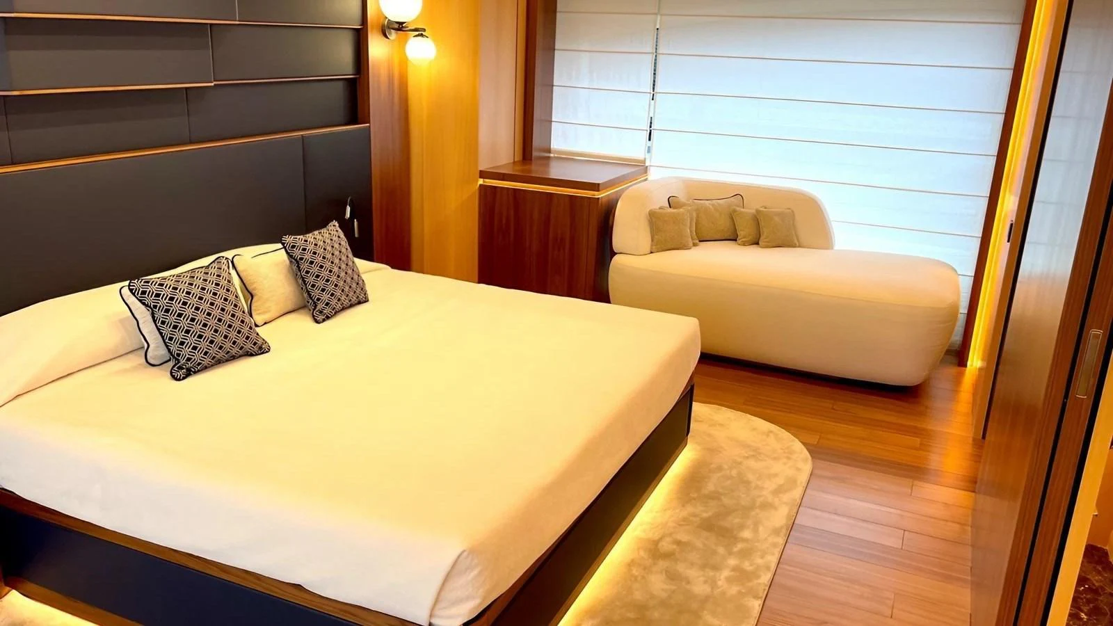 The master stateroom features a luxurious bed and a cozy seating area with elegant lighting. aboard LADY BETTY Yacht for Sale