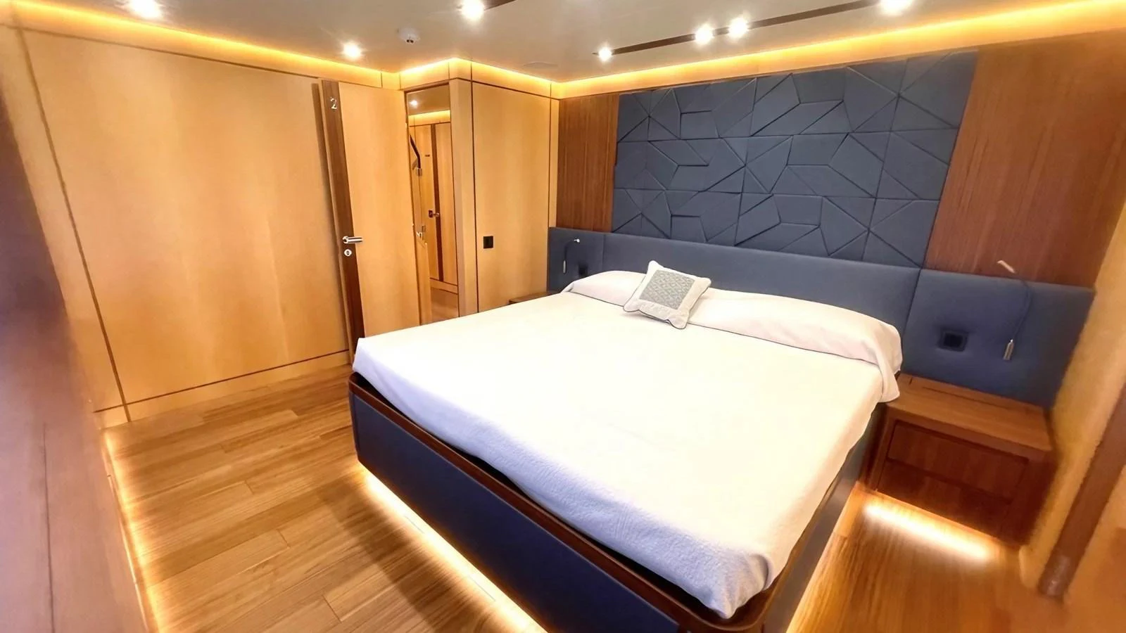 The stateroom features a spacious bed with modern lighting and elegant wood finishes. aboard LADY BETTY Yacht for Sale