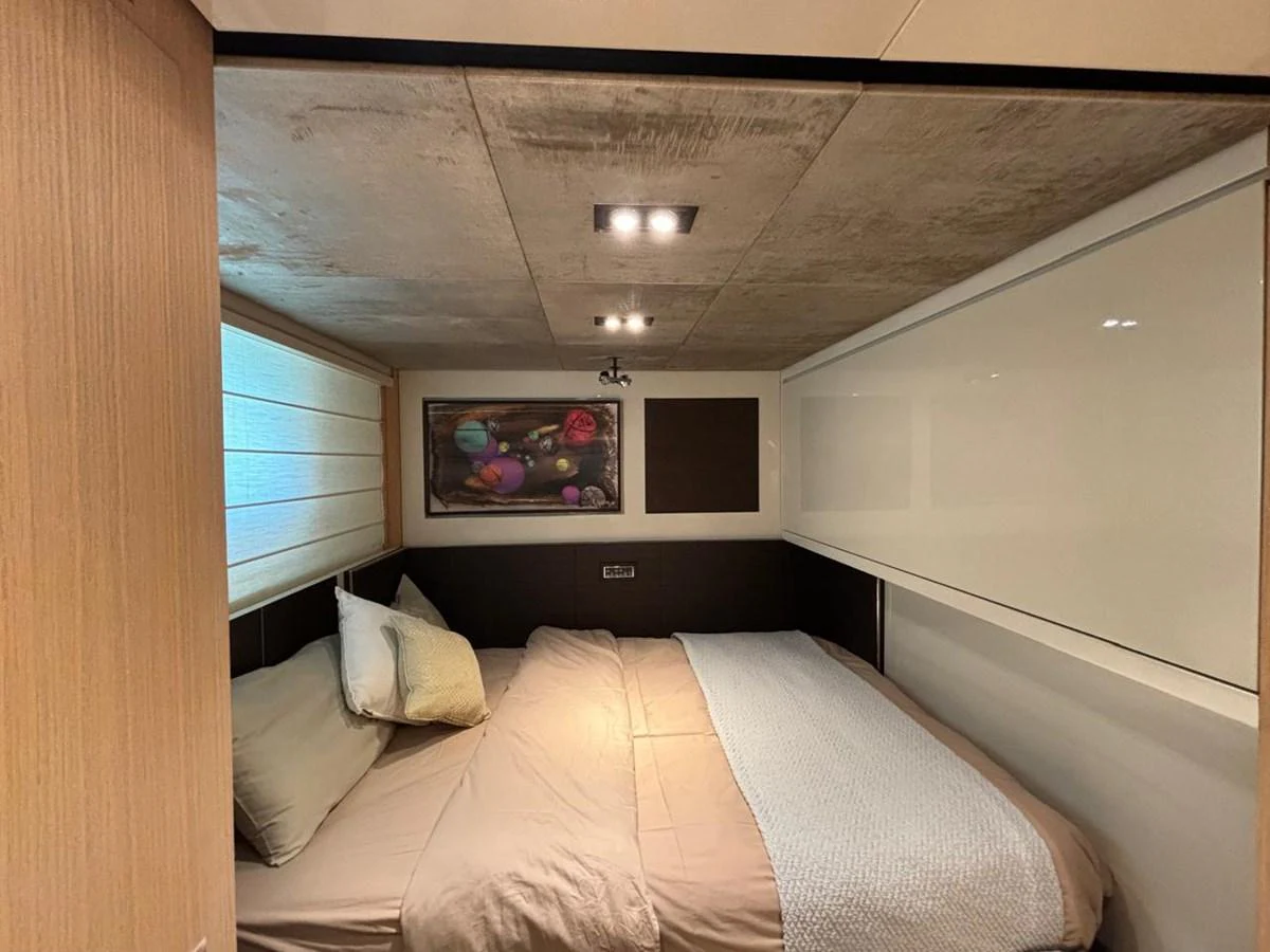 The cozy stateroom features a comfortable double bed with modern decor and ambient lighting. aboard SL94 Yacht for Sale