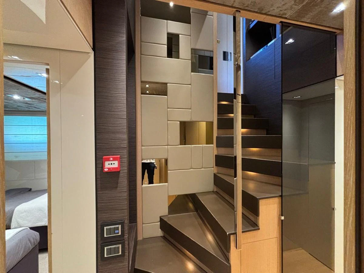 The yacht's interior features a modern staircase with sleek design elements. aboard SL94 Yacht for Sale