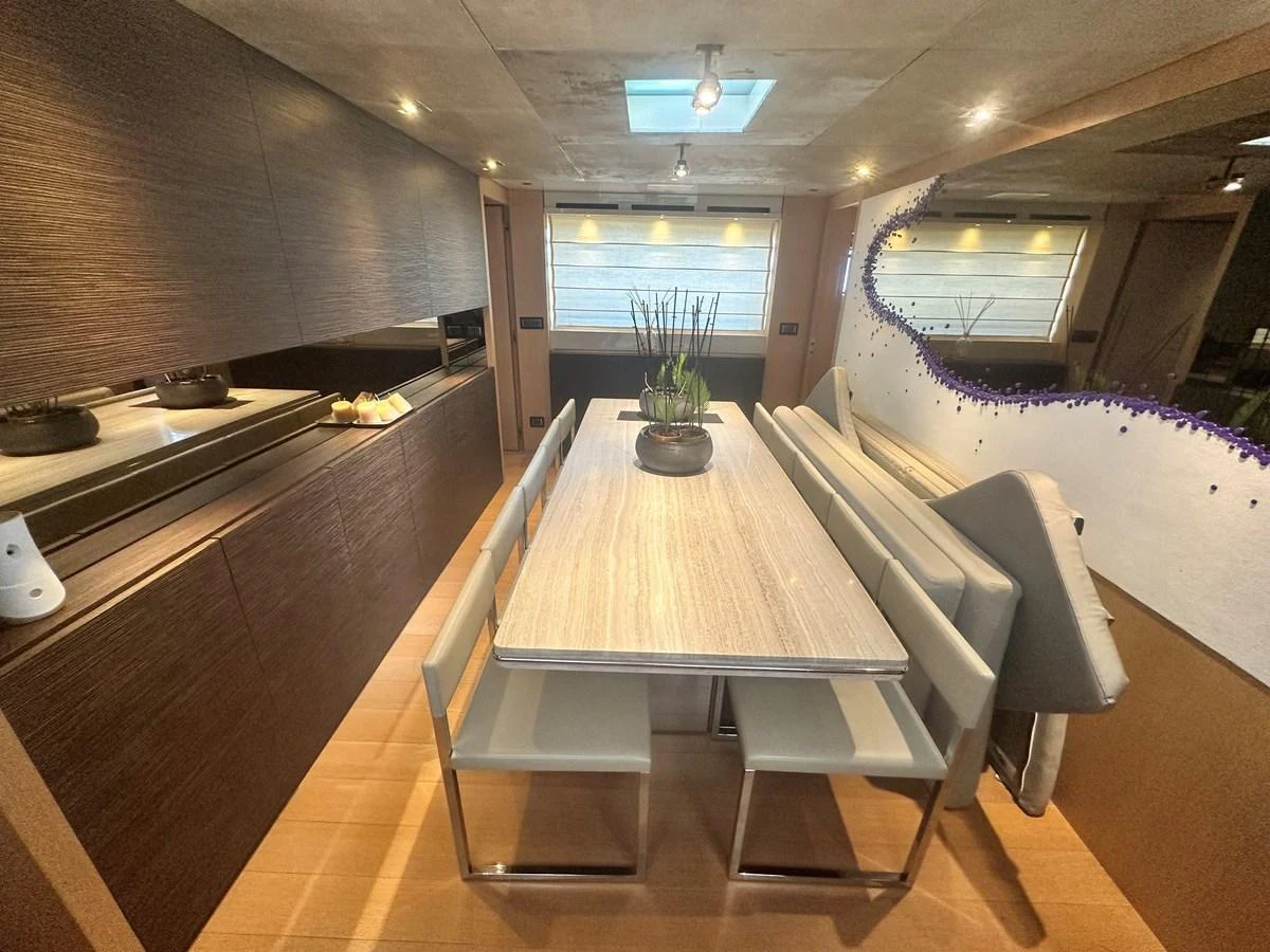 The yacht's dining area features a modern table with sleek chairs and a skylight above. aboard SL94 Yacht for Sale