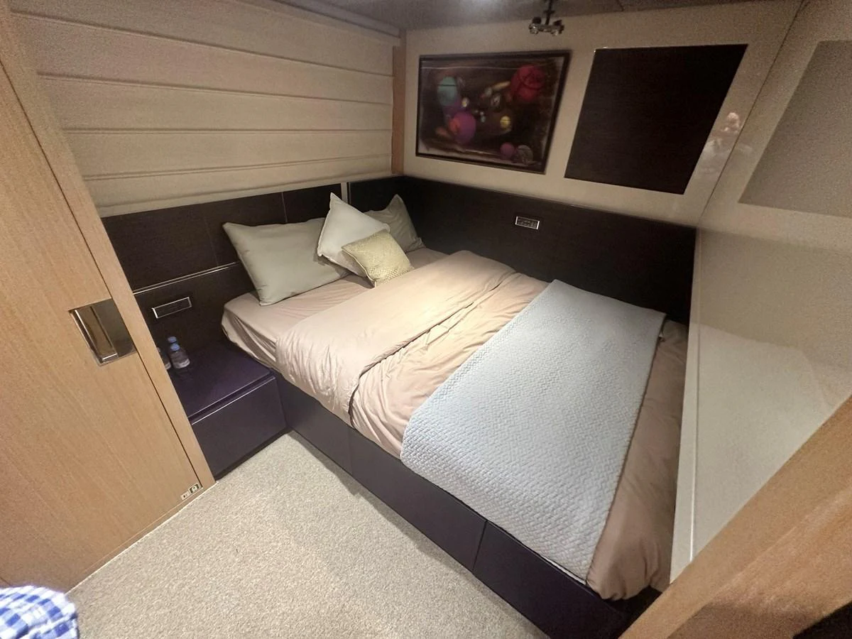 A cozy guest stateroom featuring a comfortable double bed with plush bedding and modern decor. aboard SL94 Yacht for Sale