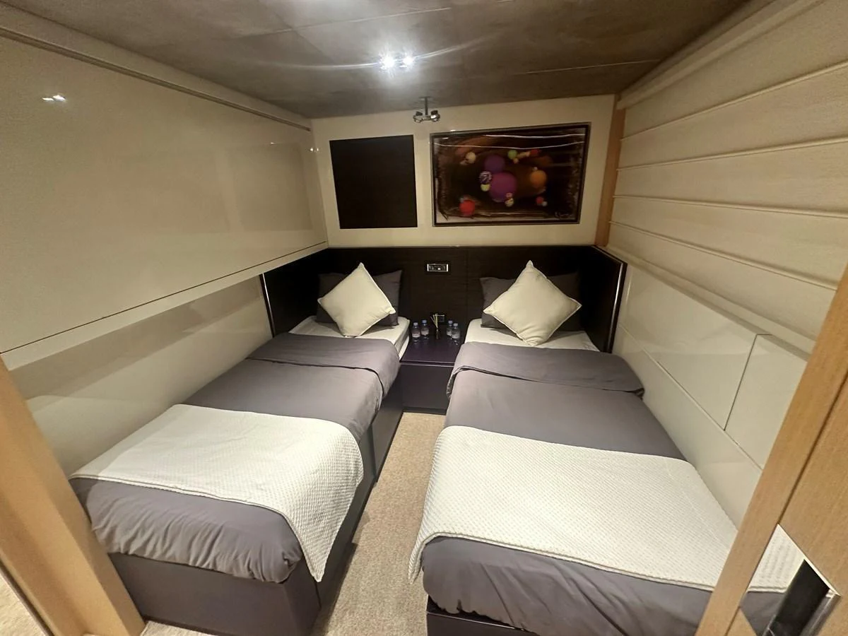 The twin stateroom features two comfortable single beds with modern decor and soft lighting. aboard SL94 Yacht for Sale