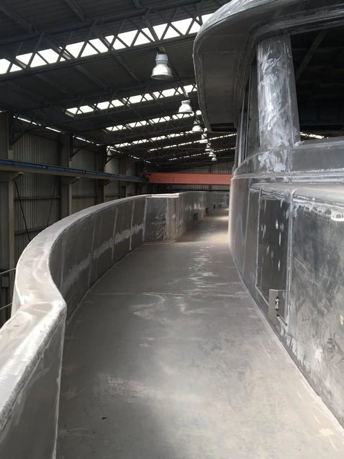 The image shows a yacht under construction in a shipyard, highlighting the unfinished exterior walkway. aboard WIDESPACE EXPLORER Yacht for Sale