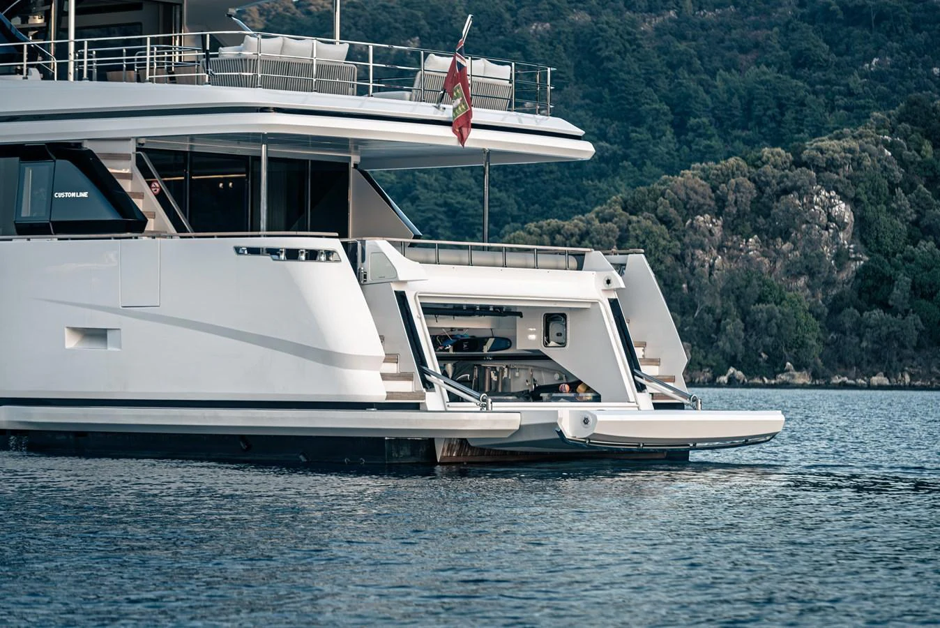The yacht's aft deck opens to reveal a luxurious beach club area, perfect for relaxation and water activities. aboard BELLE ILE Yacht for Sale