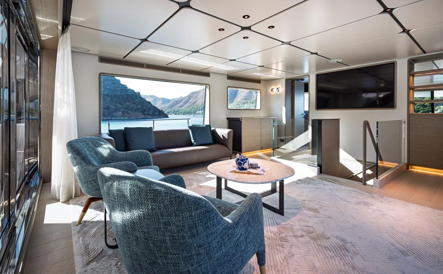The salon offers a spacious and modern living area with large windows providing stunning views. aboard BELLE ILE Yacht for Sale