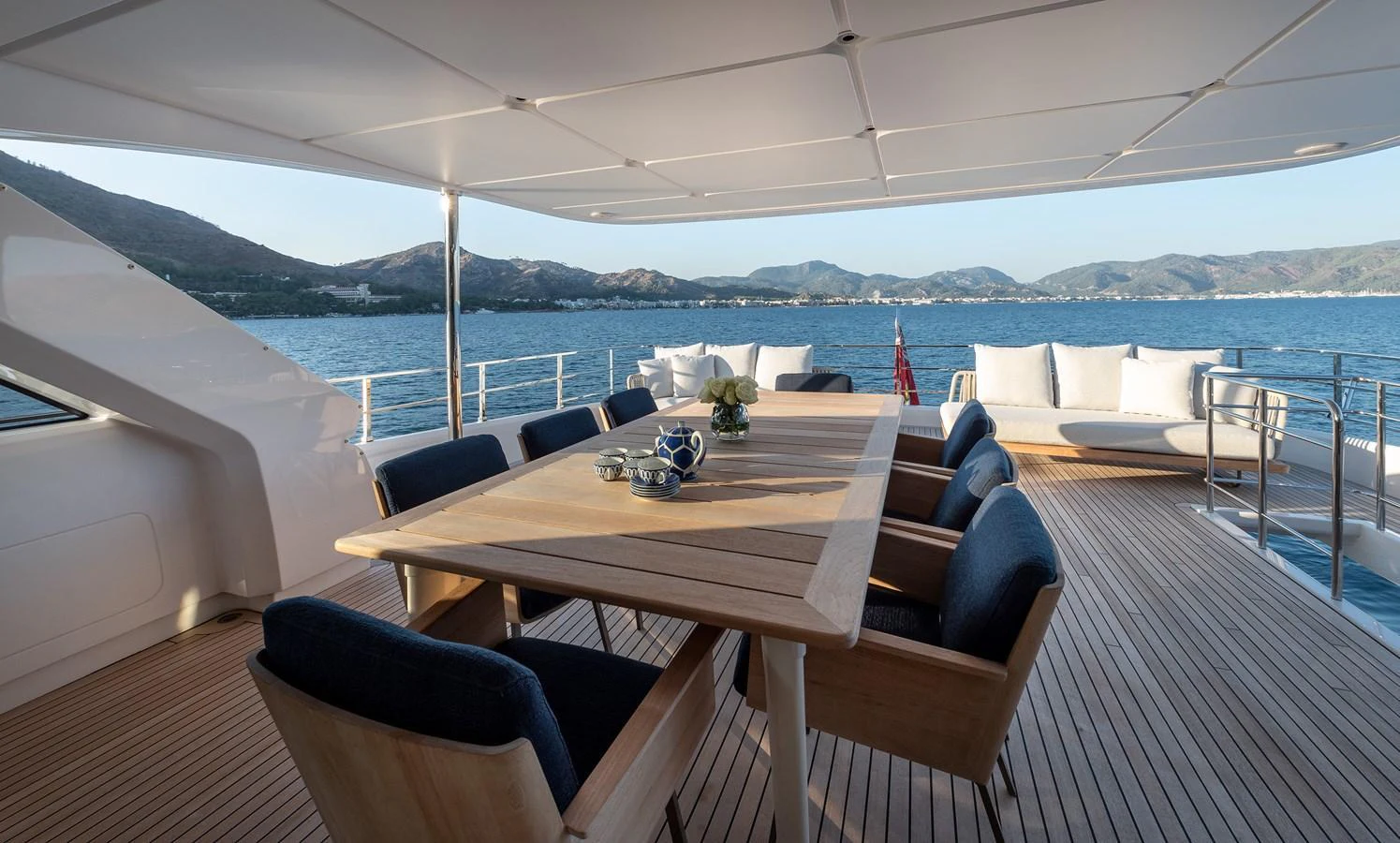 The aft deck features a spacious dining area with a large table and comfortable seating, perfect for alfresco dining with stunning sea views. aboard BELLE ILE Yacht for Sale