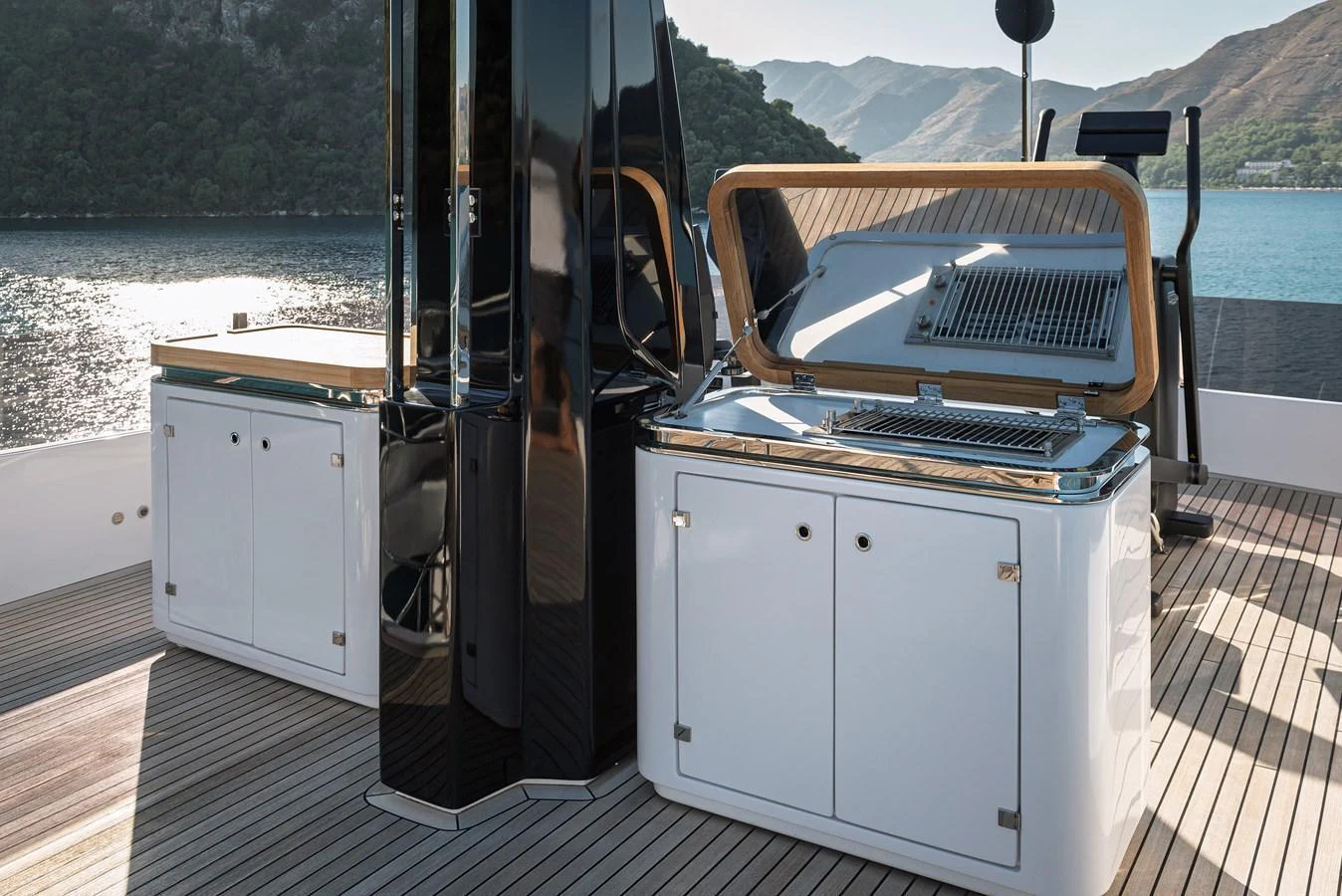 The yacht features a sleek outdoor galley with modern appliances and stunning views. aboard BELLE ILE Yacht for Sale