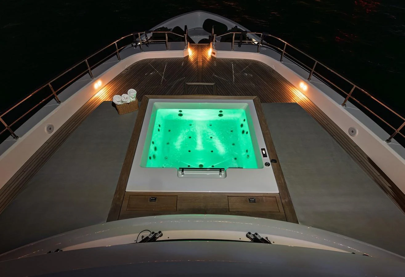 A luxurious jacuzzi on the deck of a yacht, illuminated beautifully at night. aboard BELLE ILE Yacht for Sale