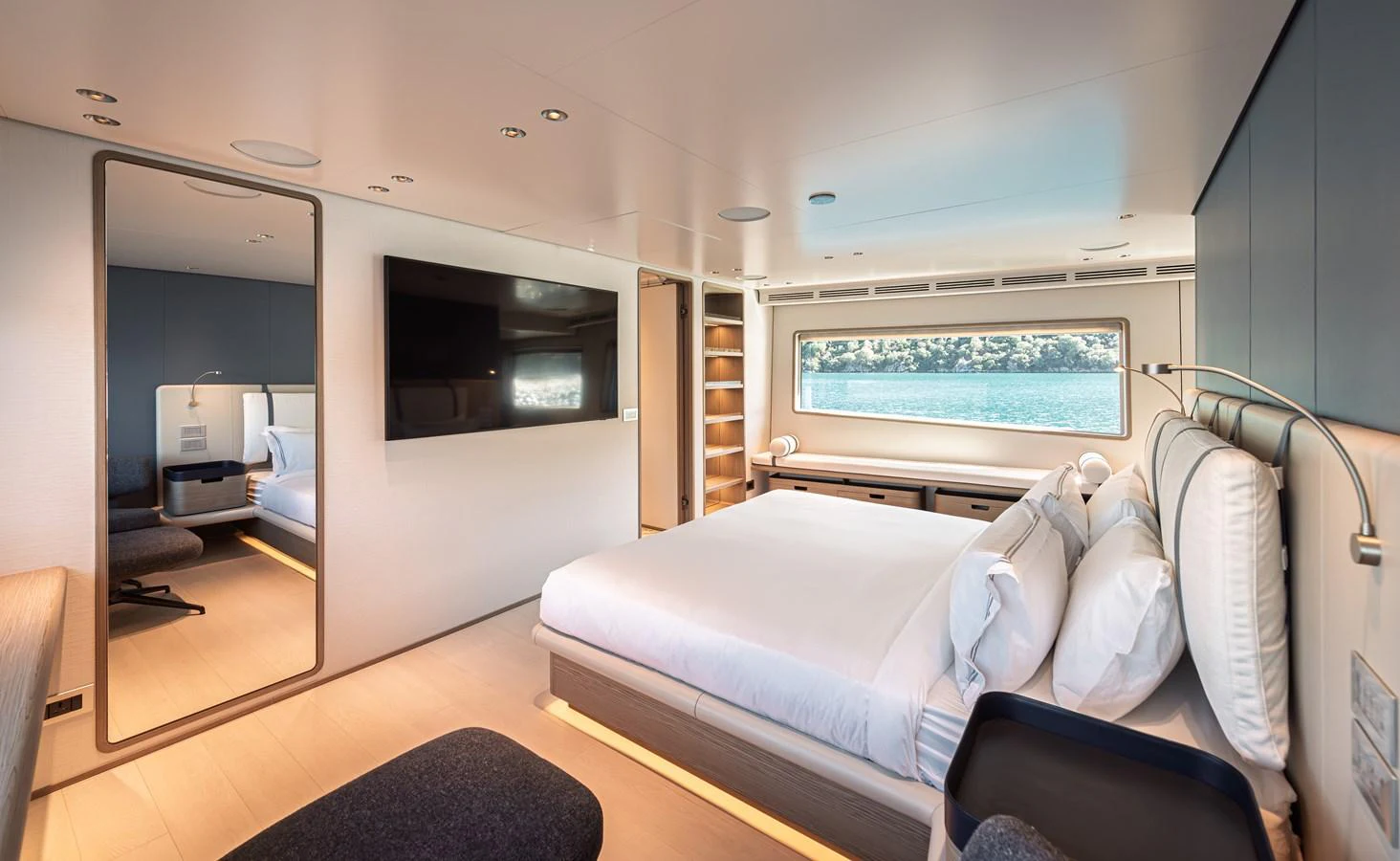 The stateroom features a spacious bed, modern decor, and large windows offering a serene view of the water. aboard BELLE ILE Yacht for Sale