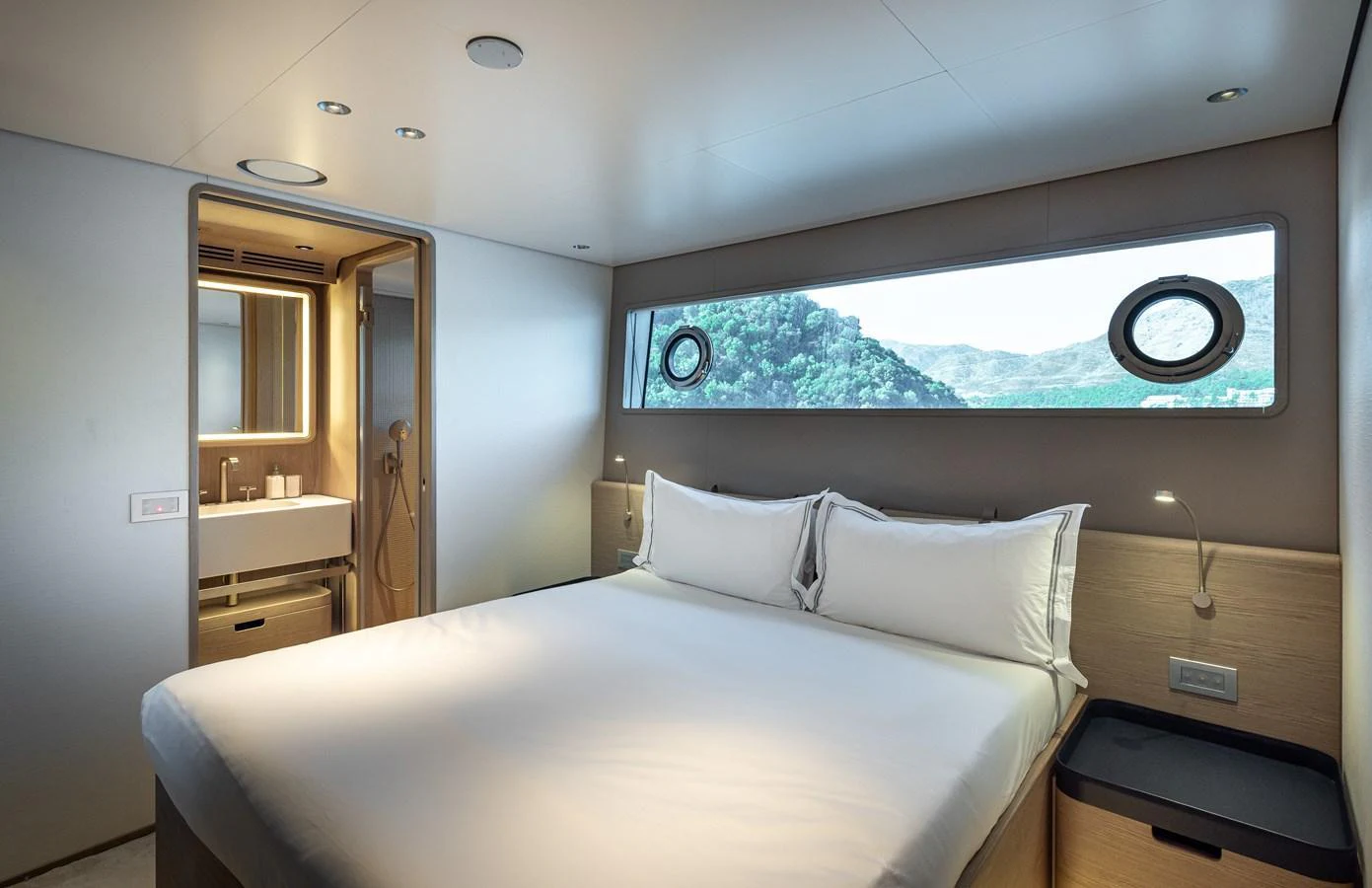 The stateroom features a comfortable bed with a scenic view through the window. aboard BELLE ILE Yacht for Sale