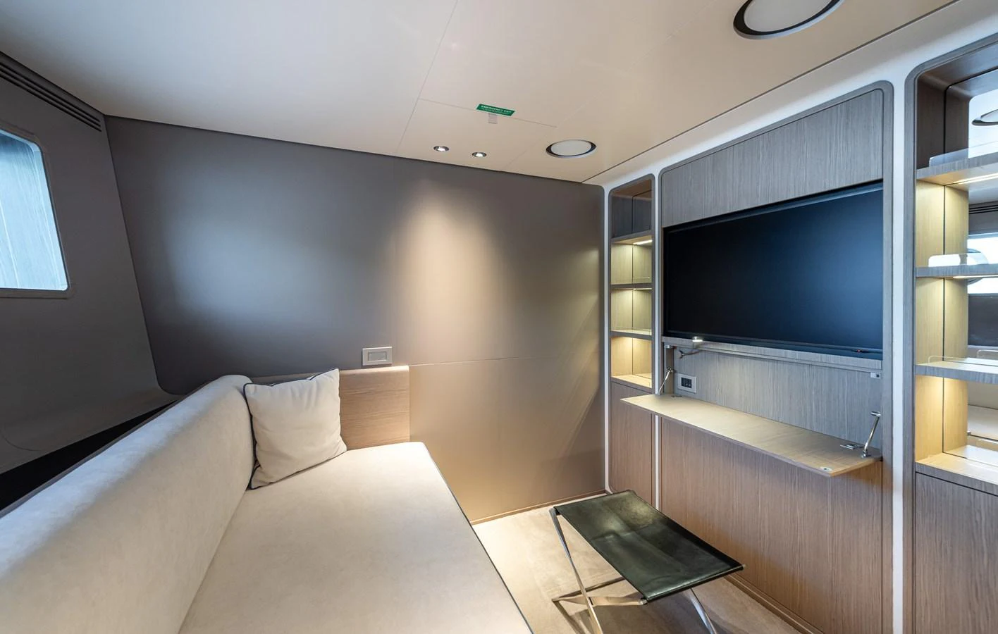 A modern and cozy lounge area featuring a comfortable sofa, a flat-screen TV, and ambient lighting. aboard BELLE ILE Yacht for Sale