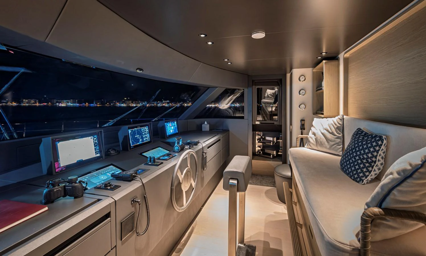 The helm station features advanced navigation equipment and a comfortable seating area with a modern, sleek design. aboard BELLE ILE Yacht for Sale