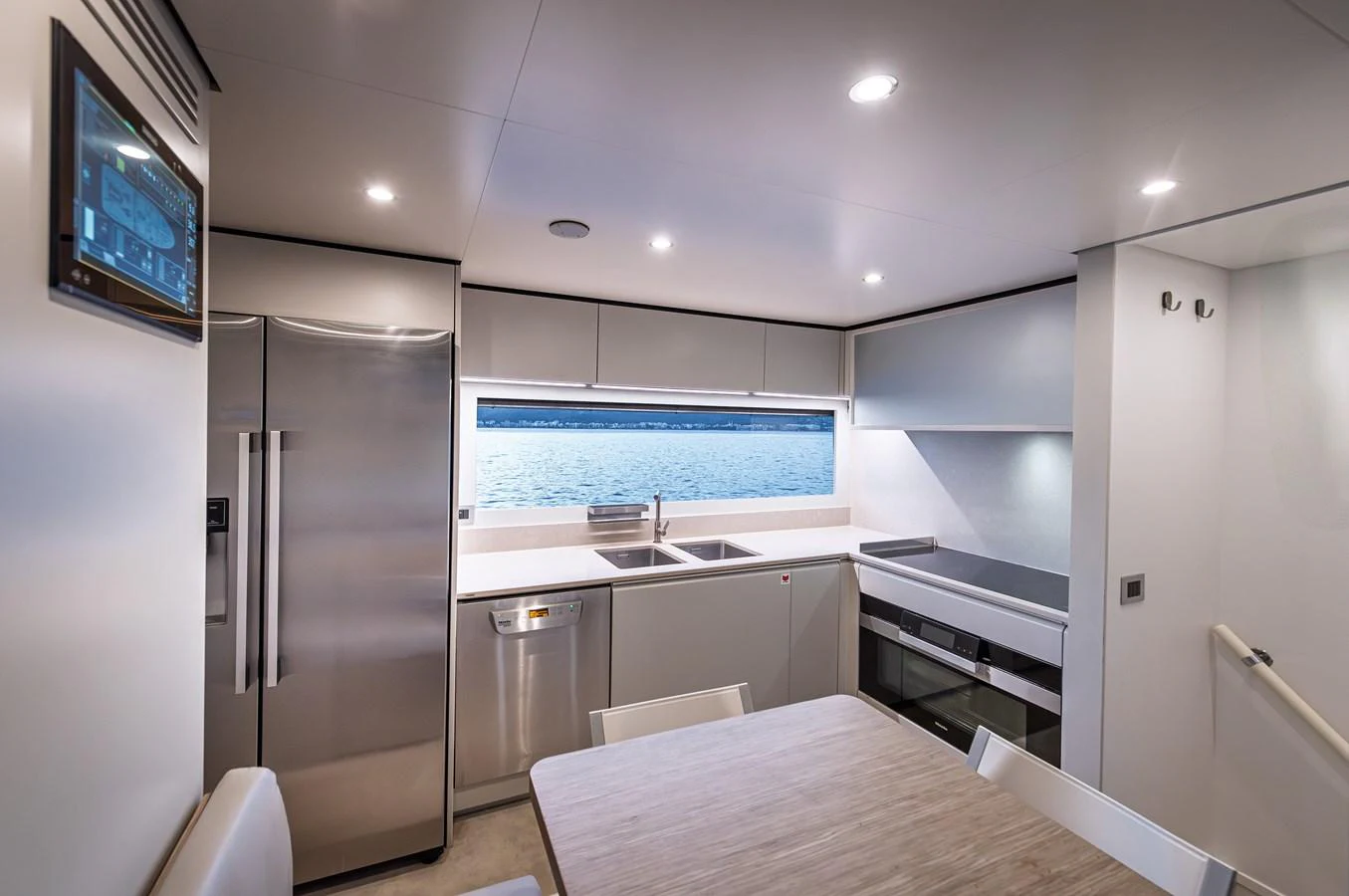 The modern galley features sleek appliances and a large window with a stunning view of the water. aboard BELLE ILE Yacht for Sale