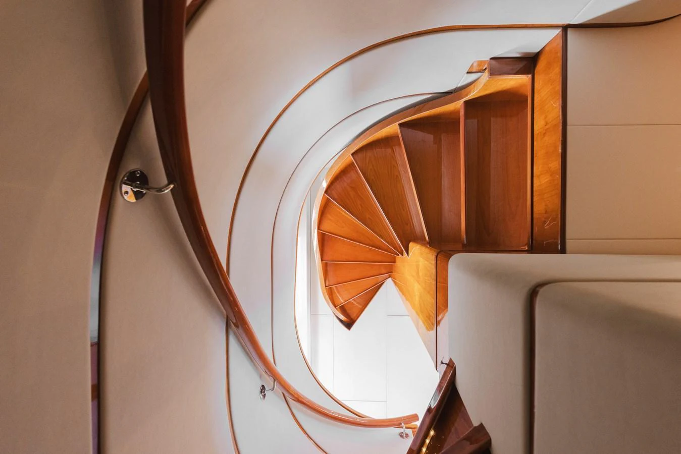 A beautifully crafted wooden spiral staircase inside the yacht. aboard SASSY Yacht for Sale