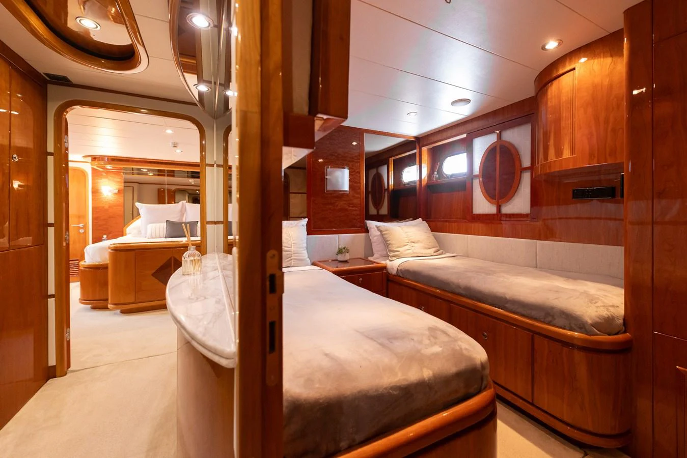 The guest stateroom features twin beds and luxurious wood finishes, creating a warm and inviting atmosphere. aboard SASSY Yacht for Sale