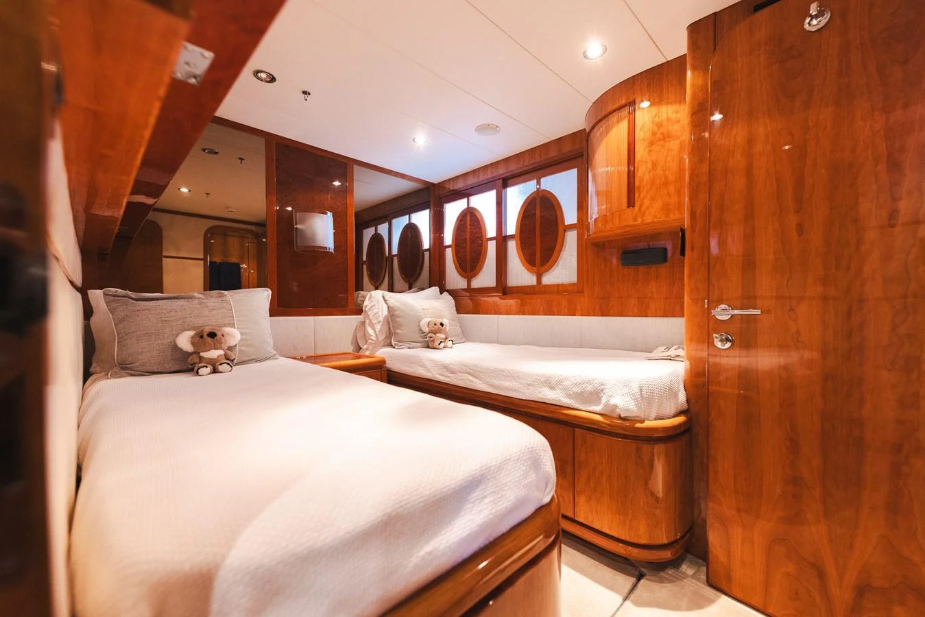 The twin stateroom features warm wood finishes and plush bedding, creating a cozy and inviting atmosphere. aboard SASSY Yacht for Sale